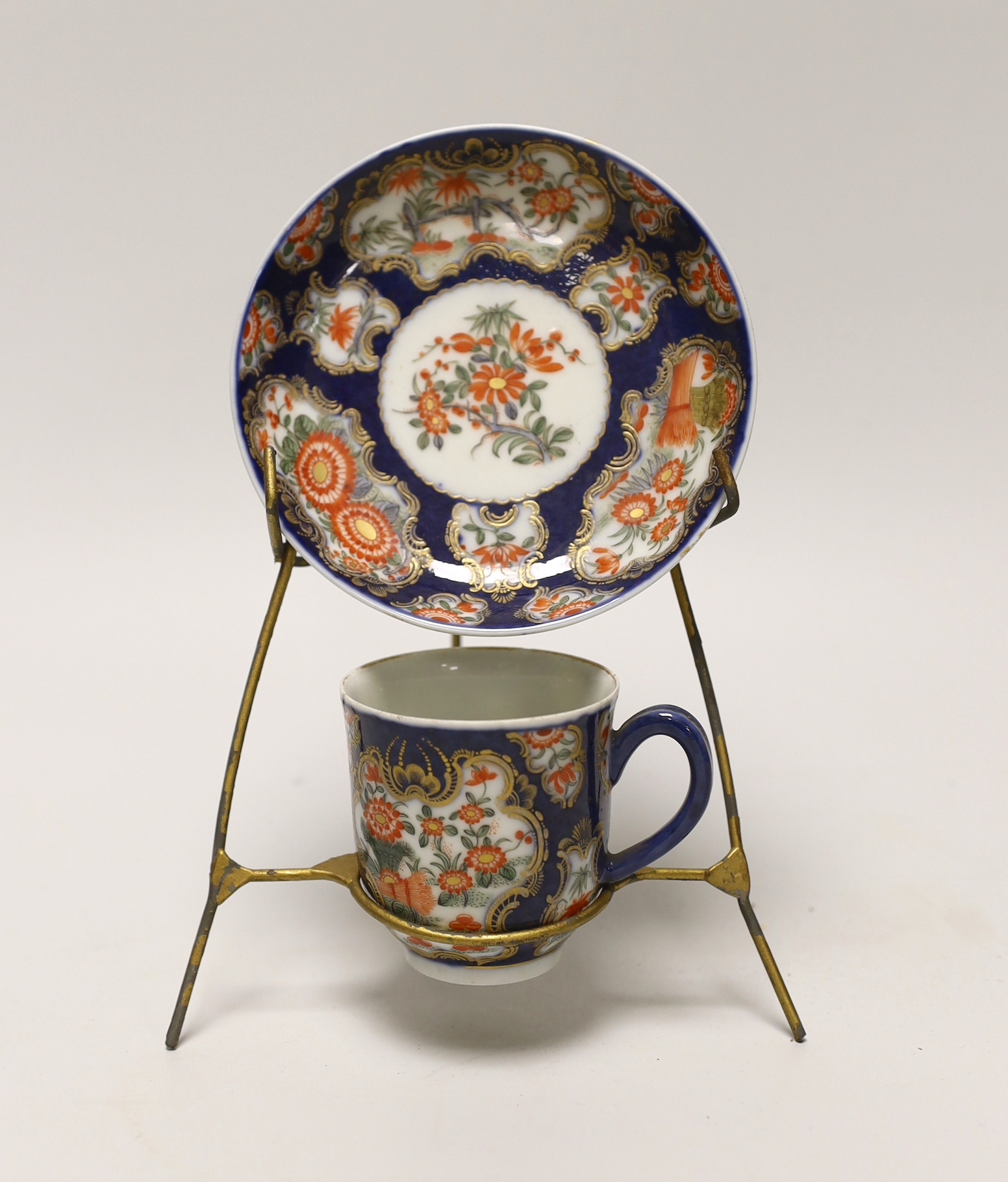 A Samson replica of a Worcester scale blue cup and saucer, hand painted with flowers on stand, the saucer 12cm in diameter